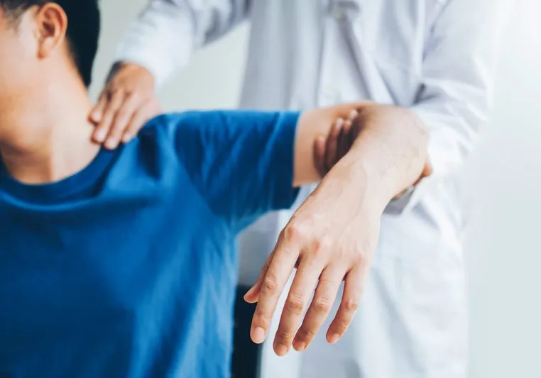 Physical Doctor consulting with patient about shoulder